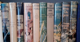Vintage hardcover Grace Livingston Hill books with dust jackets on home library shelf