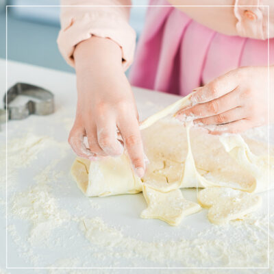 Young white woman making cookies with cookie cutter