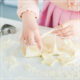 Young white woman making cookies with cookie cutter