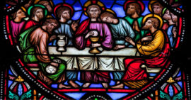 Stained glass picture of Jesus leading the last supper and communion