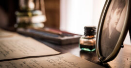 Vintage desk scene with framed photograph, ink, and paper