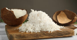 Coconuts and shredded coconut on a wooden cutting board