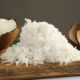 Coconuts and shredded coconut on a wooden cutting board