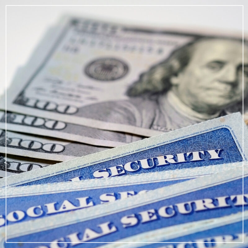 Social security cards and piles of 100 dollar bills