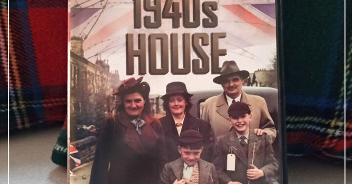 Copy of 1940s House DVD on couch with plaid pillows behind it