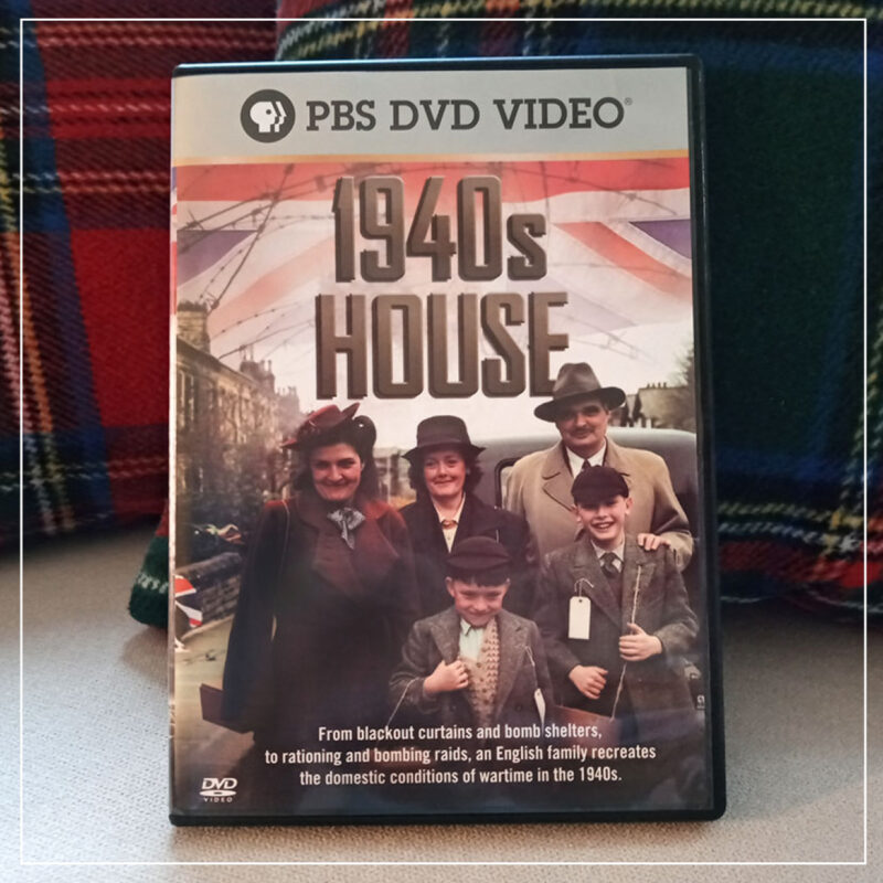 Copy of 1940s House DVD on couch with plaid pillows behind it