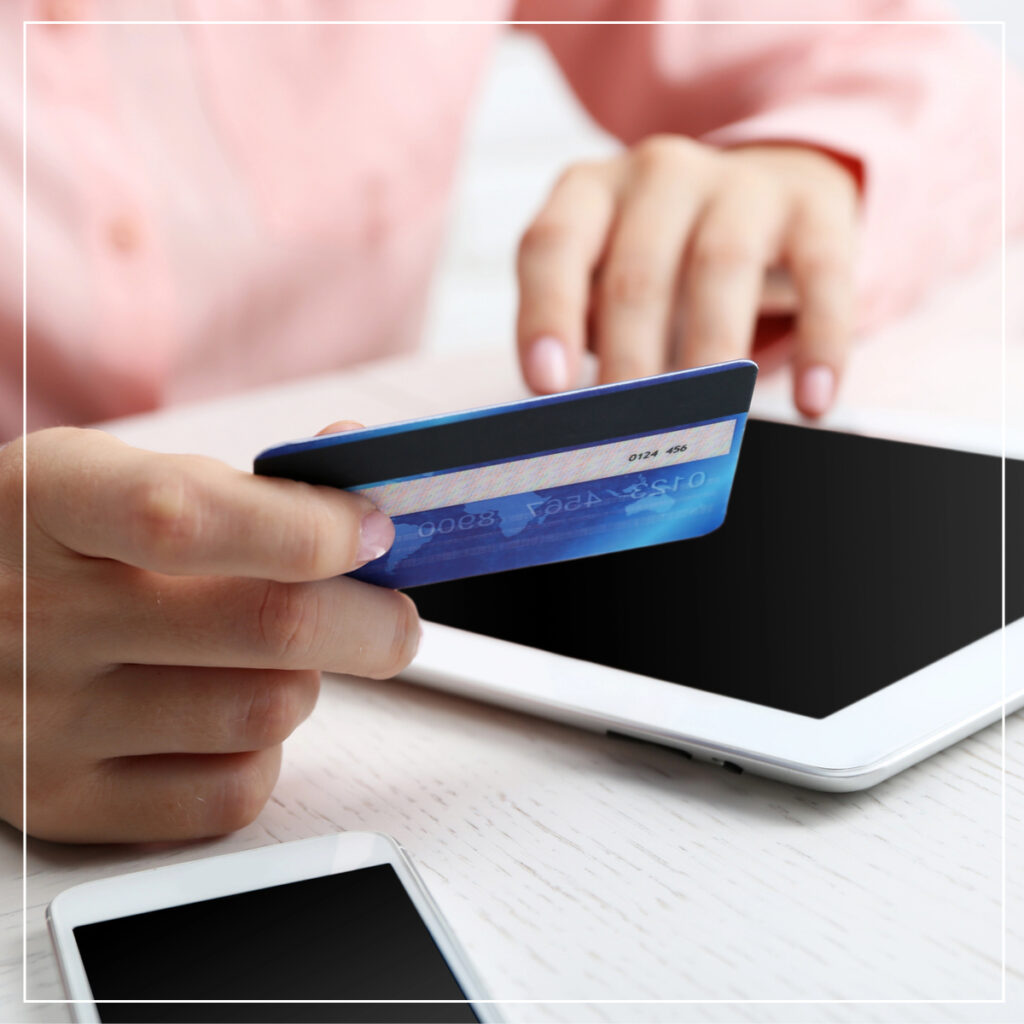 Woman in pink sweater entering credit card info into tablet