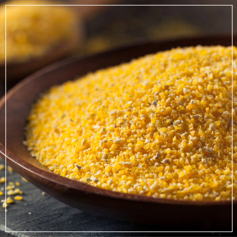 Organic corn meal in a brown wood bowl