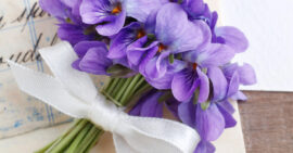Bundle of violets or violas tied with a white ribbon on a vintage letter