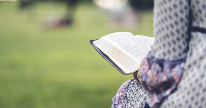 Woman reading a Bible in a park
